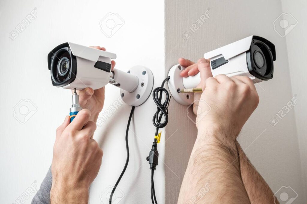 close-up-hands-of-technician-adjusting-cctv-camera-on-wall
